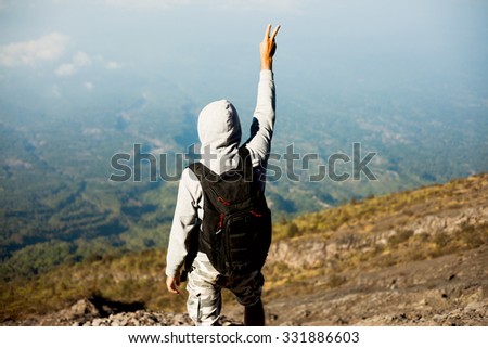 Close-up travel image,of hiker man posing on the mountain,hands up,freedom concept ,peace sign.man in cross country trail run.Fit male climbing outdoors in beautiful mountain nature landscape Iceland.