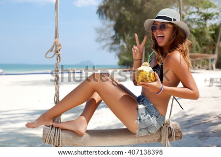 Close-up summer lifestyle tropical portrait of woman relaxing at hot sunny day over the white sand beach,Thailand,Similan islands,Hawaii USA.Drink fresh coconut and sunbathing,happy summer vacations