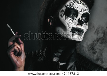 Halloween costume girl,Beautiful sexy brunette model woman.Look zombie. Creative make up.Halloween concept.Young woman in skull mask; face of a young woman in paper halloween mask;halloween concept
