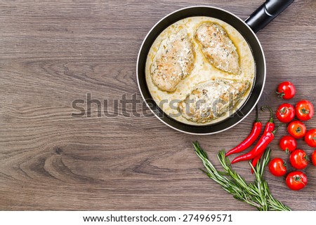 Ready chicken breast in a skillet with cream sauce.