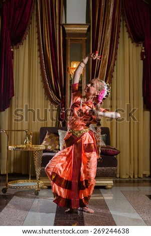 White woman is dancing in traditional indian dress