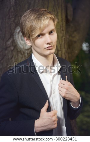 portrait of a man in a suit walking in the garden