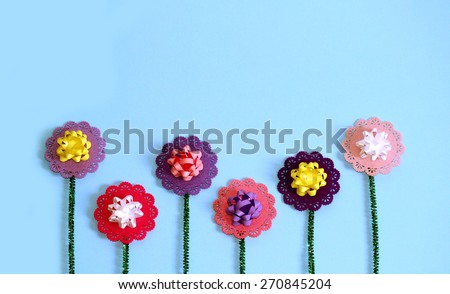 Flowers Crafted out of Pipe Cleaners and Bows in the Style of Child Art on a Blue Background, Mother\'s Day Background