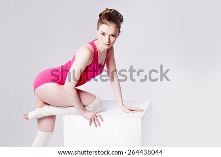 attractive young woman gymnast on a white cube,  close up