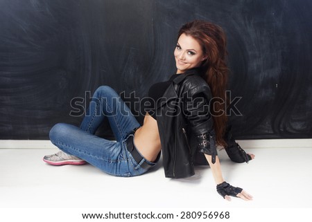 Portrait of young cheerful woman in a leather jacket