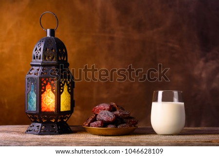 Holy month of Ramadan concept. Righteous Muslim Lifestyle. Fasting. Ramadan lantern, dates, glass of milk. Dark brown background.