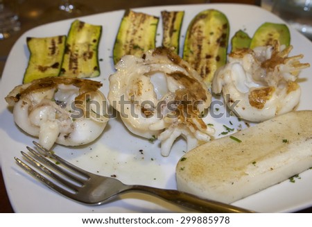 skewers of grilled cuttlefish with zucchini and white polenta, italian food