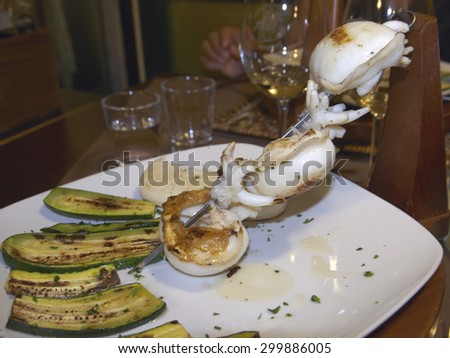 skewers of grilled cuttlefish with zucchini and white polenta, italian food