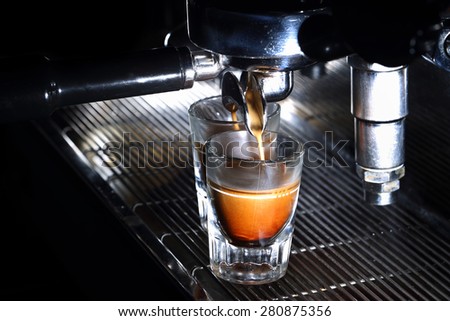 Professional espresso machine brewing a coffee. Coffee pouring into shot glasses. Toned image