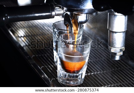 Espresso machine brewing a coffee. Coffee pouring into shot glasses. Toned image