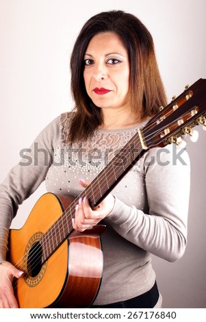 Studio shot of a woman holding guitar