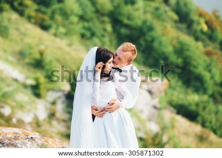 Young couple bride and groom outdoors against the backdrop of the beautiful nature. Newlyweds walking near the river