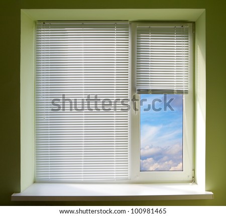 Plastic window blinds in the office with green walls.
