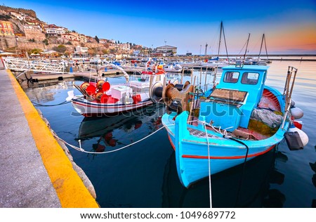 Seaside city of Kavala in Greece. Coloful evening scene, eastern Macedonia, Europe. Greek fishing boats. View on dock for boats and yachts in a beautiful spring evening.