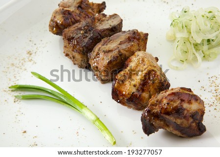 Appetizing stake with vegetables. Shish kebab isolated on white background