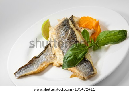 Appetizing grilled seabass fish with vegetables isolated on white background