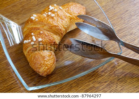 Appetizing croissant on a glass plate