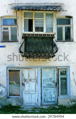 Front of a building with balcony, door and windows