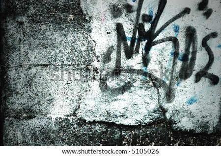 graffiti tags on grungy wall at night.