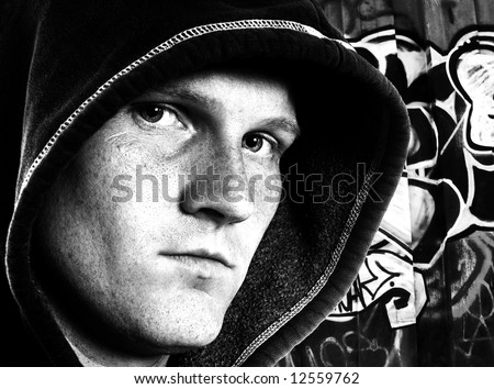 Urban hooded man with graffiti background in black and white