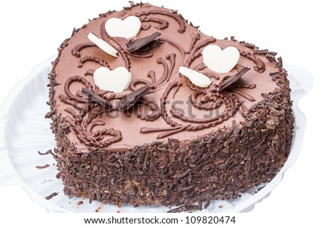 Chocolate cake in the shape of a heart on a plastic plate. Isolated on a white background.