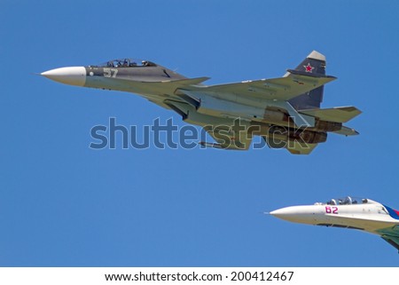 TAMBOV, RUSSIA - MAY 31, 2014:  Traditional air show in Tambov. Two  jet fighter aircrafts Su-27 (Flanker) against blue sky background. Sunny summer day
