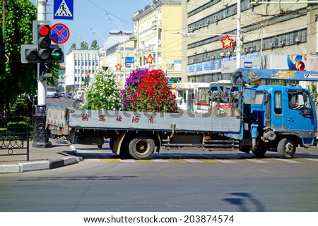 Tambov, Russia - June 3, 2014: Truck transports flower beds of flowers petunia. Urban scene in Tambov. Sunny summer day