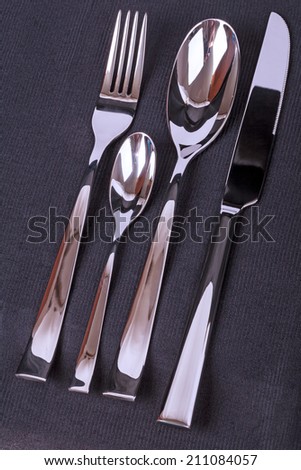 Four subjects silverware set on black fabric