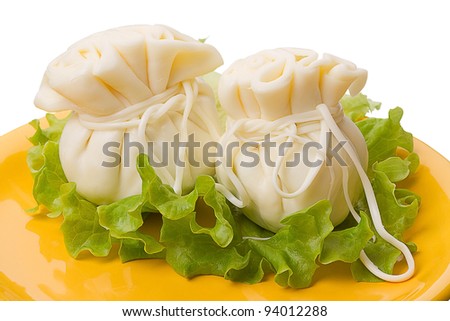 Two khinkali cheese made from natural whole milk on a yellow plate.