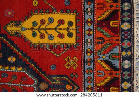 Part of the edge red woolen carpet with ethnic geometrical pattern