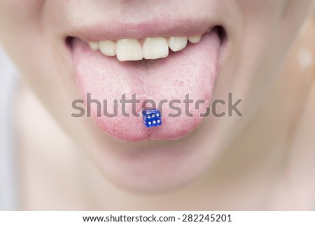 Piercing in the tongue of the girls like blue dice for the game