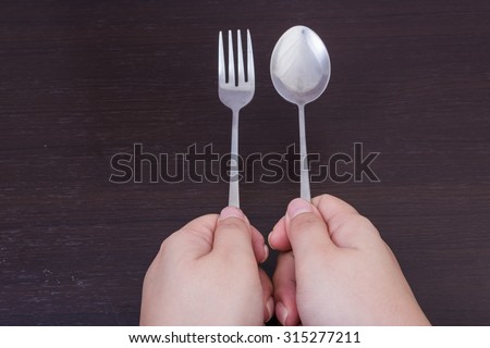 holding a stainless-steel spoon by hand