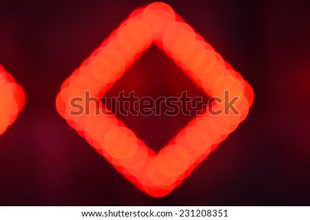 Red and black defocused light background, illumination bokeh of rhombus