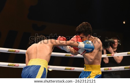 Kyiv, UKRAINE - March 20, 2015 : Hu Jianguan (China)  and VUSENALIEV Azat (UA) in the ring during boxing fight Ukraine Otamans vs China Dragons in Palace of Sport in Kiev, Ukraine