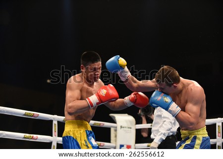 Kyiv, UKRAINE - March 20, 2015 : KHYZHNIAK Oleksandr (UA) and WANG ZHIBAO (China) in the ring during boxing fight Ukraine Otamans vs China Dragons in Palace of Sport in Kiev, Ukraine