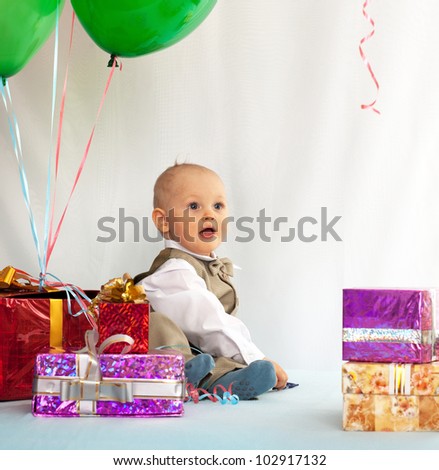 One year old baby with gifts. Day of birth.