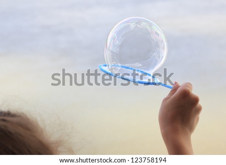 Children\'s hand with a soap bubble.