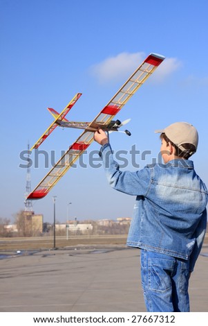 A boy starts the model of airplane in sky.