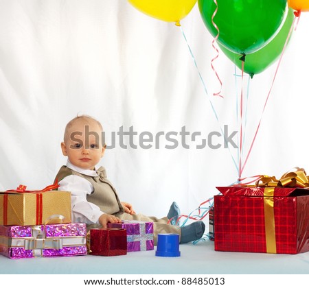One year old baby with gifts. Day of birth.