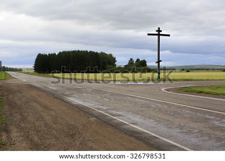 Orthodox cross on the road 1R-368. Altai Krai in Russia.