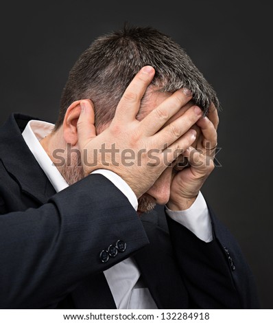 Headache. Portrait of an elderly man with face closed by hands