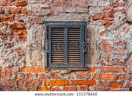 Rusty metal window on an old brick wall