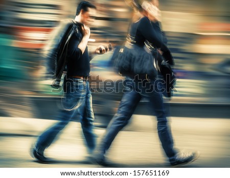 Hot Day In The City. Man And Woman Talking On A Cell Phone In A Hurry. Intentional Motion Blur And Color Shift