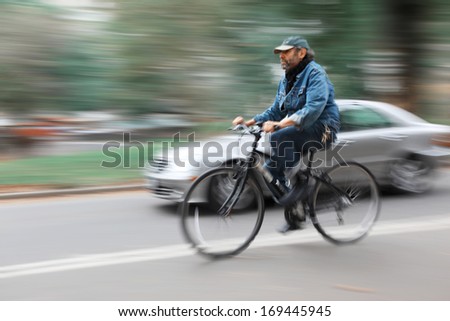 New York, Usa - Oct 16, 2013: City Traffic. Cyclist And A Car On The Streets Of New York. People Hurrying About Their Business. Image In Motion Blur Style.