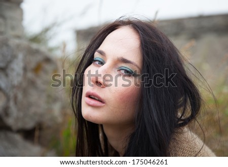 Portrait of a girl against background of nature and old concrete wall
