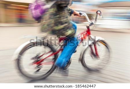 cyclist in traffic on the city roadway. Intentional motion blur