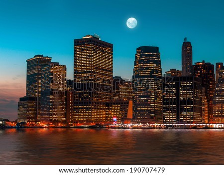 Manhattan at night with moon, lights and reflections. New York City skyline