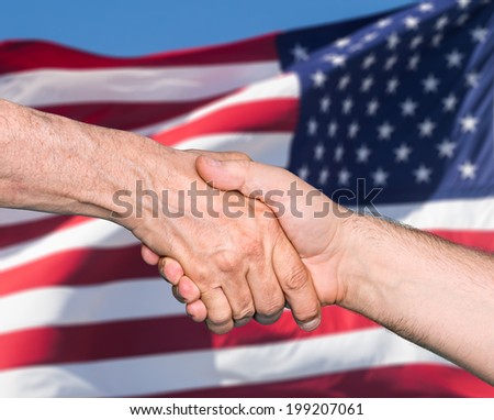 The USA flag and shaking hands of two male people