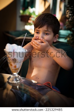 Portrait of 4-5 years old boy eating ice cream dessert