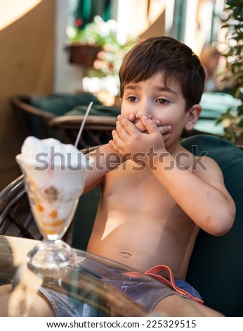 Little boy does not want to eat ice cream dessert